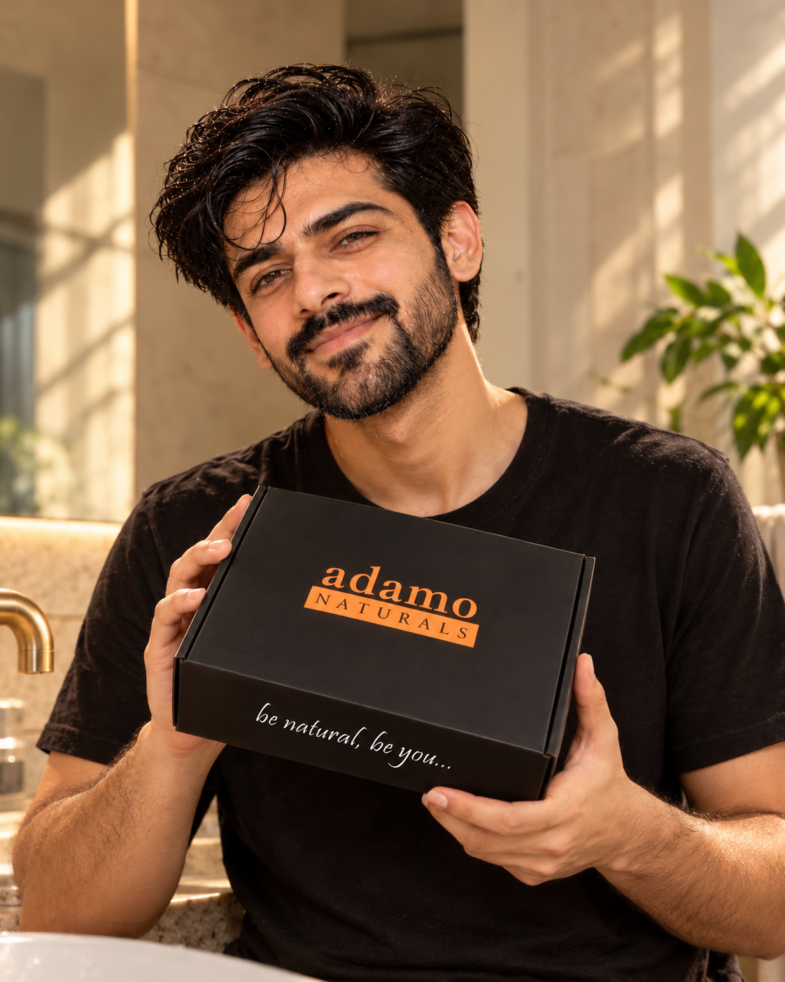 A man holding the black Adamo Naturals gift box